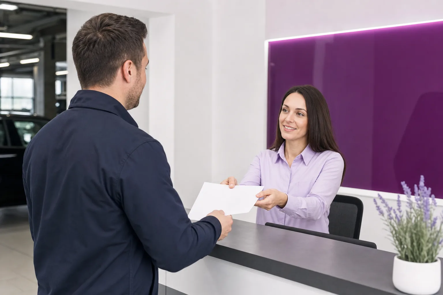 Service advisor handing written warranty document to client at oligodendro front desk, 1200x800